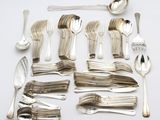 a lot of silver spoons and spoons on the table