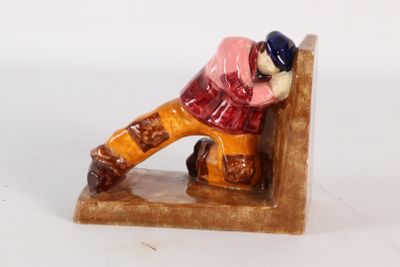 une figurine d'un homme assis sur un banc