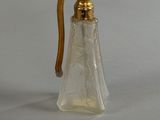 a small glass bottle with a gold handle on a table
