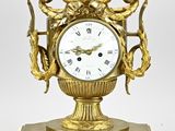 une horloge en or posée sur un socle