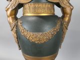 a large vase with two angels on it on a pedestal