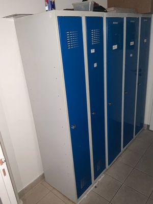 Plusieurs casiers bleus sont alignés le long d'un mur dans une pièce