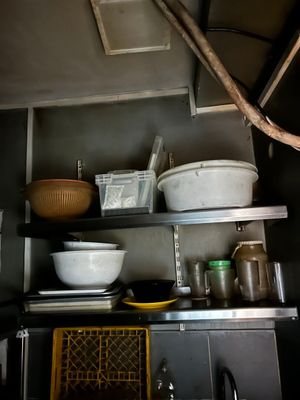 many bowls and pans on the shelves in the kitchen