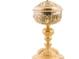 une coupe plaquée or surmontée d'une croix