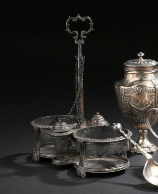 un service à thé en argent posé sur une table, avec une cuillère et une tasse