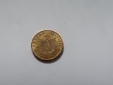 an old gold coin on a white surface