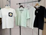 three t - shirts hanging on a clothes rack in a room