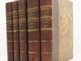 three books are stacked on top of each other on a white surface