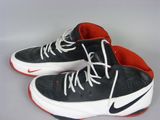 pair of black and white sneakers with red soles on a white surface