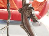 a statue of a horse on a table with a red couch in the background
