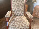 a chair that has a floral upholstered seat on it