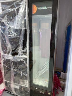 un réfrigérateur emballé dans du plastique et posé dans une pièce