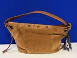 un sac à main marron posé sur une table près d'un mur bleu