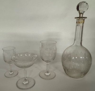 four wine glasses and a decanter sitting on a table