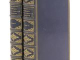 Deux livres bleus aux bords dorés sont empilés l'un sur l'autre
