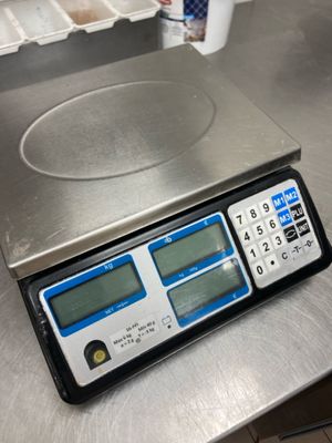 a digital scale sitting on top of a metal counter