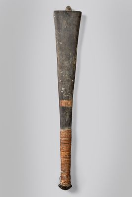 une vieille batte de baseball accrochée au mur, avec un manche en bois