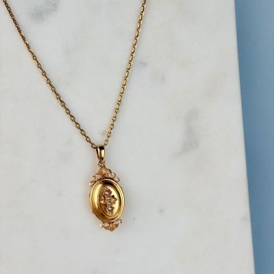 un gros plan d'un collier « Gold Locke » posé sur une surface en marbre