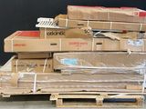 une pile de cartons posée sur une palette devant un mur noir