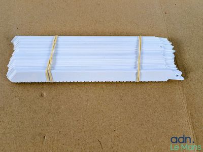 un gros plan sur un tas de bâtonnets en papier blanc posés sur une surface marron