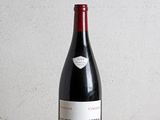 la bouteille de vin rouge est posée sur une table en bois