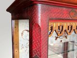 a glass display case with a red and gold design on it