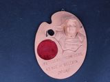 une médaille sur laquelle figurent l'image d'un homme et un point rouge