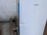 a white refrigerator sitting on a pallet in a warehouse