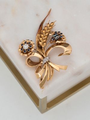 une broche en or sertie de pierres noires et blanches