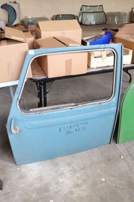 une voiture bleue dans un garage, avec des cartons par terre