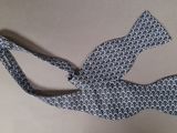 bow tie with a blue and white pattern on a tan background