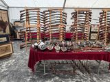 une table recouverte d'une nappe rouge sur laquelle sont posées plusieurs armes à feu