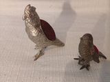 deux oiseaux qui sont posés l'un à côté de l'autre sur un canapé
