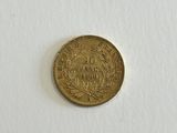 a gold coin sitting on top of a white surface