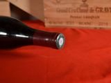 a bottle of wine sitting on a table next to a wooden box