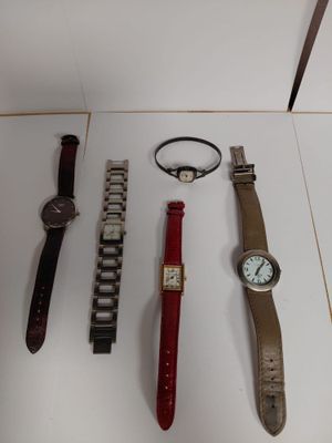 several watches and bracelets are displayed on a white surface