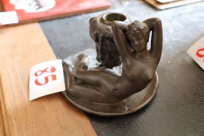 une statue représentant une femme tenant un vase posé sur une table
