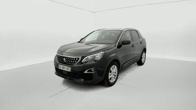 La voiture noire est garée dans une pièce blanche au sol blanc.