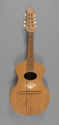 un gros plan d'une guitare en bois sur fond gris