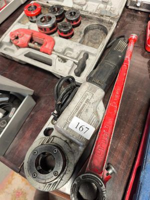 une table sur laquelle sont posés des outils, notamment une perceuse, un marteau et d'autres outils