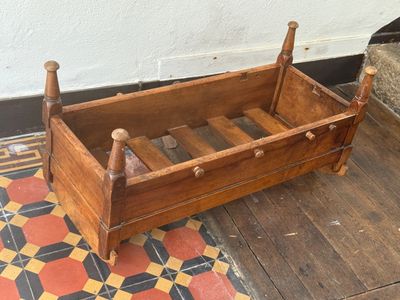 a small wooden bed with a wooden frame on the floor