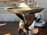 a bird that is sitting on top of a bowl on a table