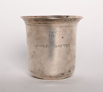 une coupe en argent ancienne sur laquelle est gravé le nom « Émile Bauter »