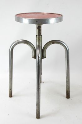 une image représentant un tabouret en métal avec une assise rose sur fond blanc