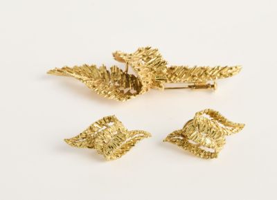 trois broches en feuille d'or sur un fond blanc