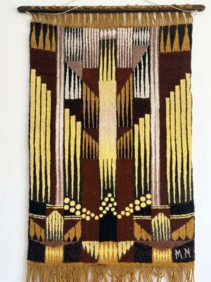 a wall hanging made of a tapestry with a cross on it