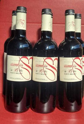 six bottles of wine are lined up on a red chair