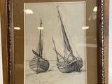 framed drawing of a pair of boats on display in a glass case
