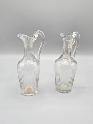 une paire de vases en verre transparent posés sur une table blanche