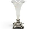 une image représentant un vase en argent posé sur un socle, sur fond blanc